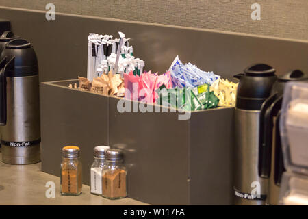 NEW YORK, USA - MAY 15, 2019: Counter in Starbucks cafe with Straws and sugar to pick up to go Stock Photo