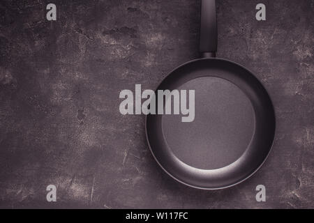 Kintchen Frying Pan on Dark Surface. Empty Culinary Background. Stock Photo