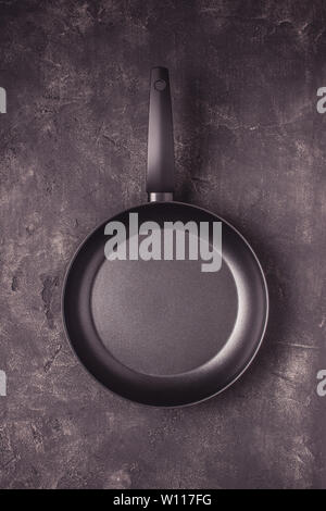 Kintchen Frying Pan on Dark Surface. Empty Culinary Background. Stock Photo