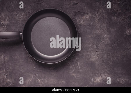 Kintchen Frying Pan on Dark Surface. Empty Culinary Background. Stock Photo