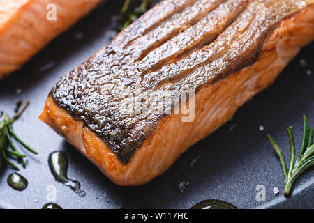 Grilled Salmon Steaks in Frying Pan with Garlic and Rosemary. Healthy Eating Concept. Stock Photo