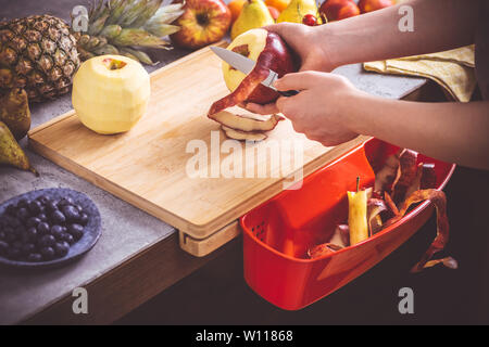 Female Hands Peeling Fresh Organic Apple with Small Knife. Healthy Eating Vegan Raw Food Concept. Stock Photo
