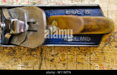 Metal smoothing plane No 4 'made in england' detail on aged woodworking bench grunge surface, shot from above. Stock Photo