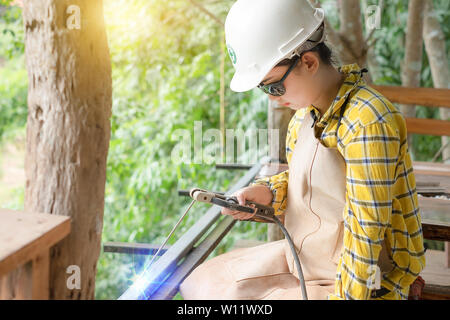 Young women in are welding steel with blue sparks flying Stock Photo