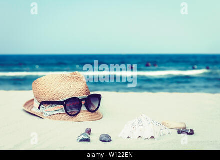 Vintage wicker straw hat and black sun glasses on a tropical beach, summer concept Stock Photo