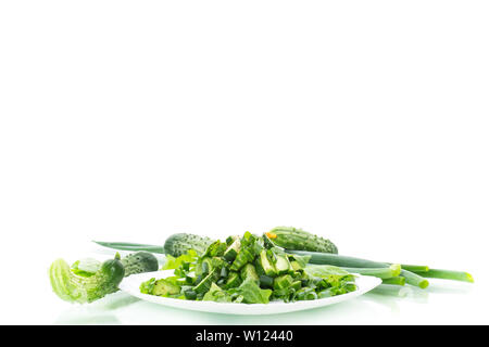 fresh salad of cucumbers and greens in a plate isolated on white background Stock Photo