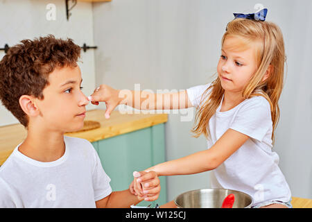 close-up Brother and sister in the kitchen preparing food, dessert for the family. Stock Photo