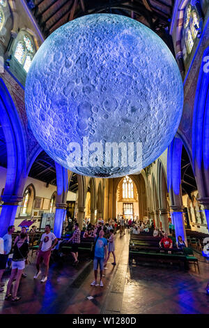 Bournemouth, Dorset, UK. 29th June, 2019. Visitors enjoy and take photos of Luke Jerram's internationally acclaimed Museum of the Moon. An art installation visiting Bournemouth until the 30th June 2019, housed in St Peter's Church in the town cente. Credit: Thomas Faull/Alamy Live News Stock Photo