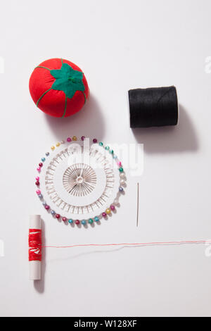 White copy space with red thread and push pins and cushion, sewing supplies Stock Photo