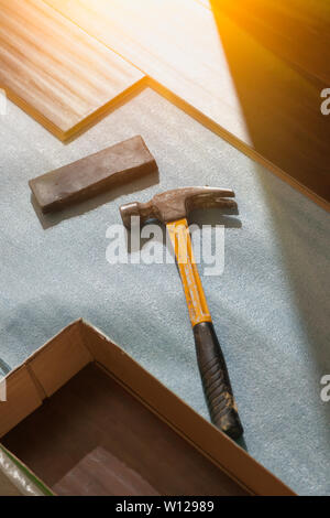 Hammer and Block with New Laminate Flooring Abstract. Stock Photo