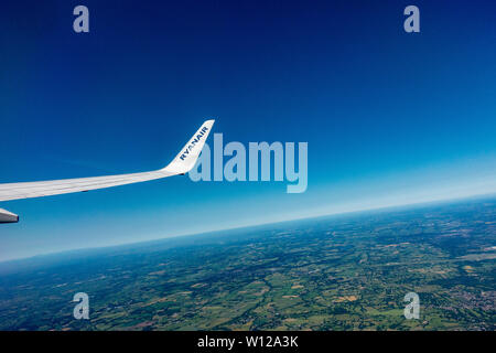 A Ryanair 737 - 800 wing and wing tip with the French Mediterranean horizon below Stock Photo