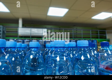 Plastic bottles with mineral water on the shop counter. Stock Photo