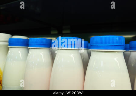 Plastic milk bottles on the store counter. Stock Photo