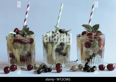 Summer refreshing cocktail of natural fruits and various berries with ice and mint leaves infused with water. Contains lemon, orange, strawberry, cher Stock Photo