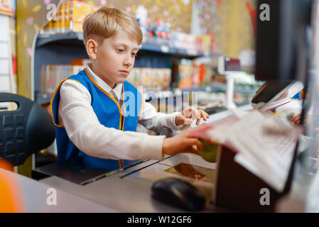 Boy in uniform at the register playing salesman Stock Photo