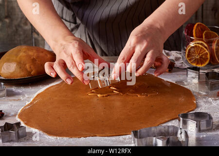 Woman's hands make gingerbread cookies shapes from dough Stock Photo