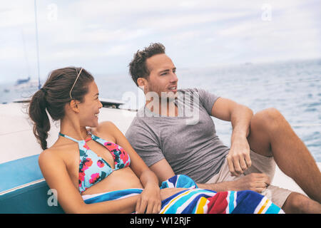 Yacht boat lifestyle couple talking on cruise ship in Hawaii holiday . Two tourists getaway enjoying summer vacation, woman relaxing in bikini. Stock Photo