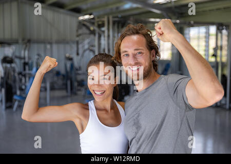 Funny fitness couple. Funky girl have bodybuilding practice, show biceps. A  young female model posing with male big muscles. Fun fitness. Woman power  Stock Photo - Alamy