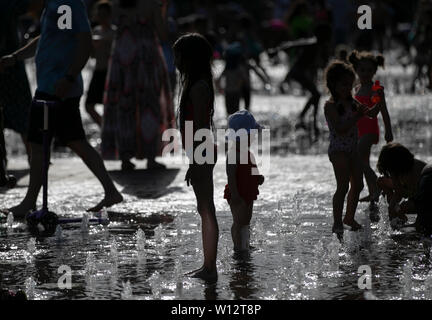 London, UK. 29th June, 2019. Children play on a square fountain in London, UK, on June 29, 2019. Temperatures soared in the UK on Saturday as the island country saw its hottest day of the year. A scorching 34 degrees Celsius was recorded at Heathrow and elsewhere in west London, making it one of the warmest June days for about 40 years, the Met Office said. Credit: Han Yan/Xinhua/Alamy Live News Stock Photo