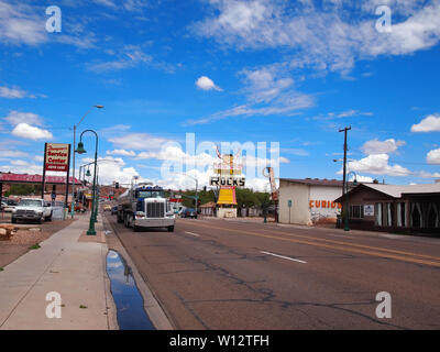 HOLBROOK, ARIZONA - JULY 12, 2018: A semi truck, tractor trailer driving on historic Route 66 through Holbrook, past the landmark Pow Wow Rock Shop, w Stock Photo