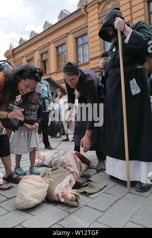 Turku, Finland. 29th June, 2019. Tourists interact with a girl who is performing a historical street play in Turku, southwestern Finland, on June 29, 2019. The annual Medieval Market, one of the largest historical events in Finland, is held in Turku from June 27 to June 30. Modern people can enjoy ancient music and dance, historical street plays, traditional food and handicrafts during the event. Credit: Zhang Xuan/Xinhua/Alamy Live News Stock Photo