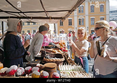 Turku, Finland. 29th June, 2019. Tourists queue for traditional candy apples in Turku, southwestern Finland, on June 29, 2019. The annual Medieval Market, one of the largest historical events in Finland, is held in Turku from June 27 to June 30. Modern people can enjoy ancient music and dance, historical street plays, traditional food and handicrafts during the event. Credit: Zhang Xuan/Xinhua/Alamy Live News Stock Photo