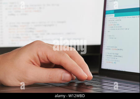 Creating computer code close up view on blurred background Stock Photo