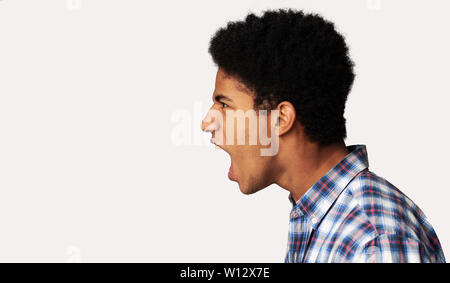 Furious Afro Guy Shouting over Light Background Stock Photo