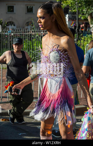 NEW YORK CITY - JUNE 25, 2017: A transgender woman wears an eye-catching outfit as she passes the crowds at the annual gay pride parade in the Village. Stock Photo