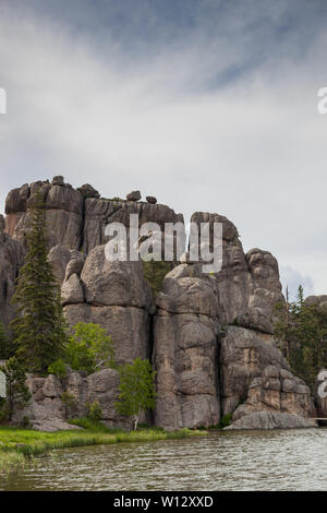 Large granite rock formations along the shoreline of  Sylvan Lake in South Dakota. Stock Photo