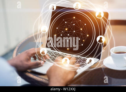 Social network hologram with businessman working on laptop Stock Photo