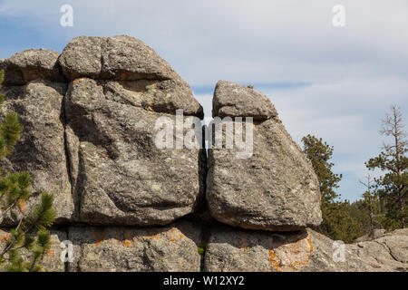 Large granite rock formations and trees along the shoreline of  Sylvan Lake in South Dakota. Stock Photo