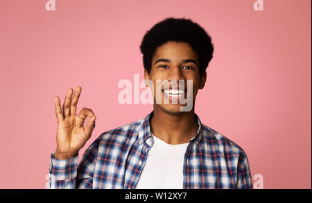 Happy Afro Guy Gesturing OK Sign and Smiling Stock Photo