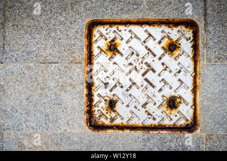 Rusted metal plate as waste water drainage cover Stock Photo
