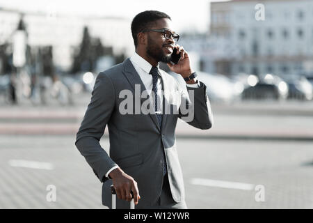 Calling Taxi at Airport. Businessman Talking on Phone Stock Photo