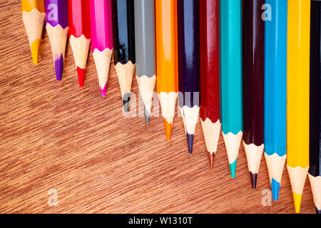 A neatly arranged colored pencil on a wooden board. Stock Photo