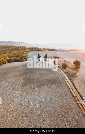 Aerial drone view of Cappella della Madonna di Vitaleta, Tuscany, Italy. Traditional italian architecture. Autumn landscape of Tuscan hills San Quiric Stock Photo