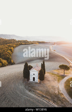 Aerial drone view of Cappella della Madonna di Vitaleta, Tuscany, Italy. Traditional italian architecture. Autumn landscape of Tuscan hills San Quiric Stock Photo