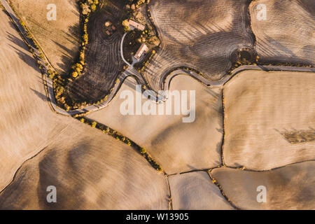 Aerial drone landscape of famous Tuscany hills, Italy. Abstract view of curved serpentine road with cypress alley. Empty agricultural fields in autumn Stock Photo