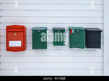 Colors vintage mailboxes along on wooden wall at residential Stock Photo