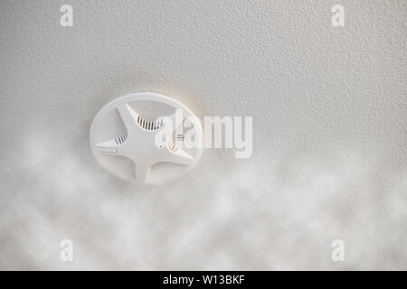 Install fire alarm signal protection on ceiling with smoke effect in house Stock Photo