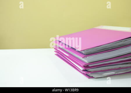 Stack of account file documents on white desk with yellow background Stock Photo