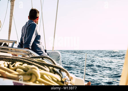 Free man enjoying outdoor leisure activity on a sail boat with blue ocean around - luxury summer holiday vacation concept - Happy people sailing with Stock Photo