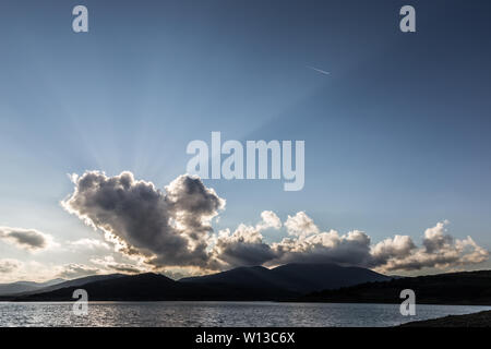 Sunrays shining through cloud over Montedoglio lake (Tuscany, Italy) Stock Photo