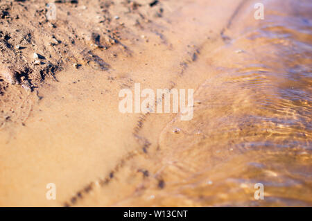 Sandy river bank with small river waves. Pure clear water Stock Photo