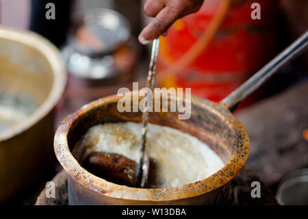 Tea boiling in a dirty open saucepan on a roadside stall in indian city Stock Photo