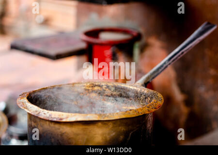 Tea boiling in a dirty open saucepan on a roadside stall in indian city Stock Photo