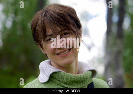 Portrait of a smiling young woman outdoors in nature Stock Photo