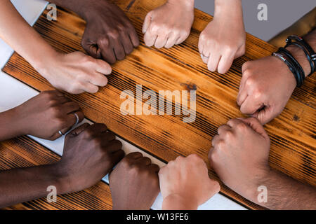 Close up of multiracial students hands making fist bump gesture. Stock Photo