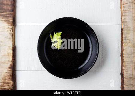 Cooking background concept. Empty rustic black cast iron plate over wooden background. Stock Photo